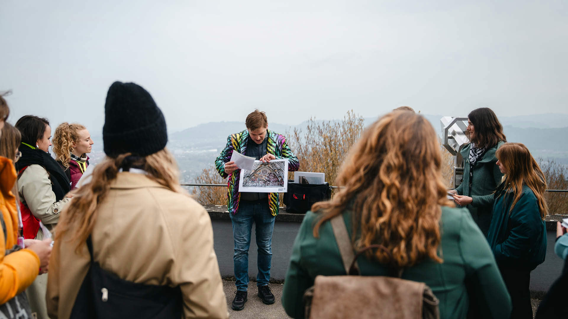 Several people are looking at pictures on a guided tour at Gurten.