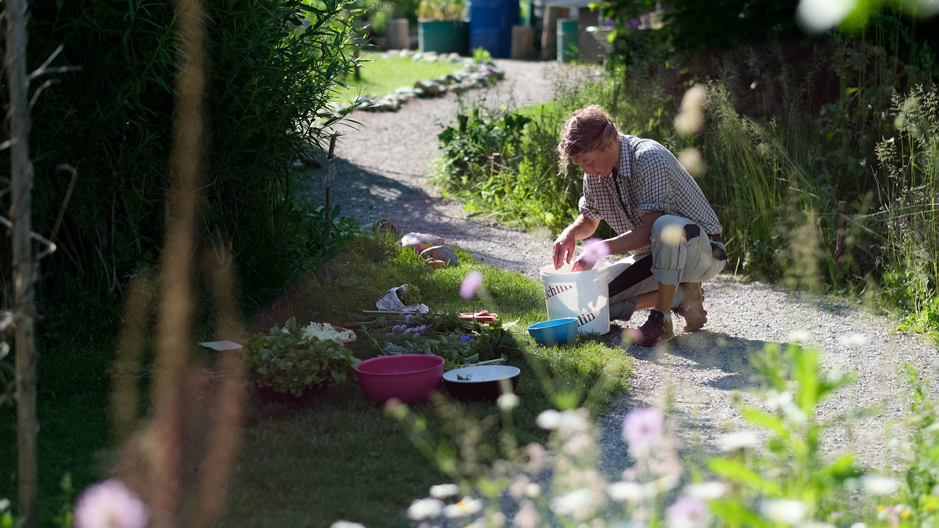A woman taking something out of a bucket in the Gurtengärtli.