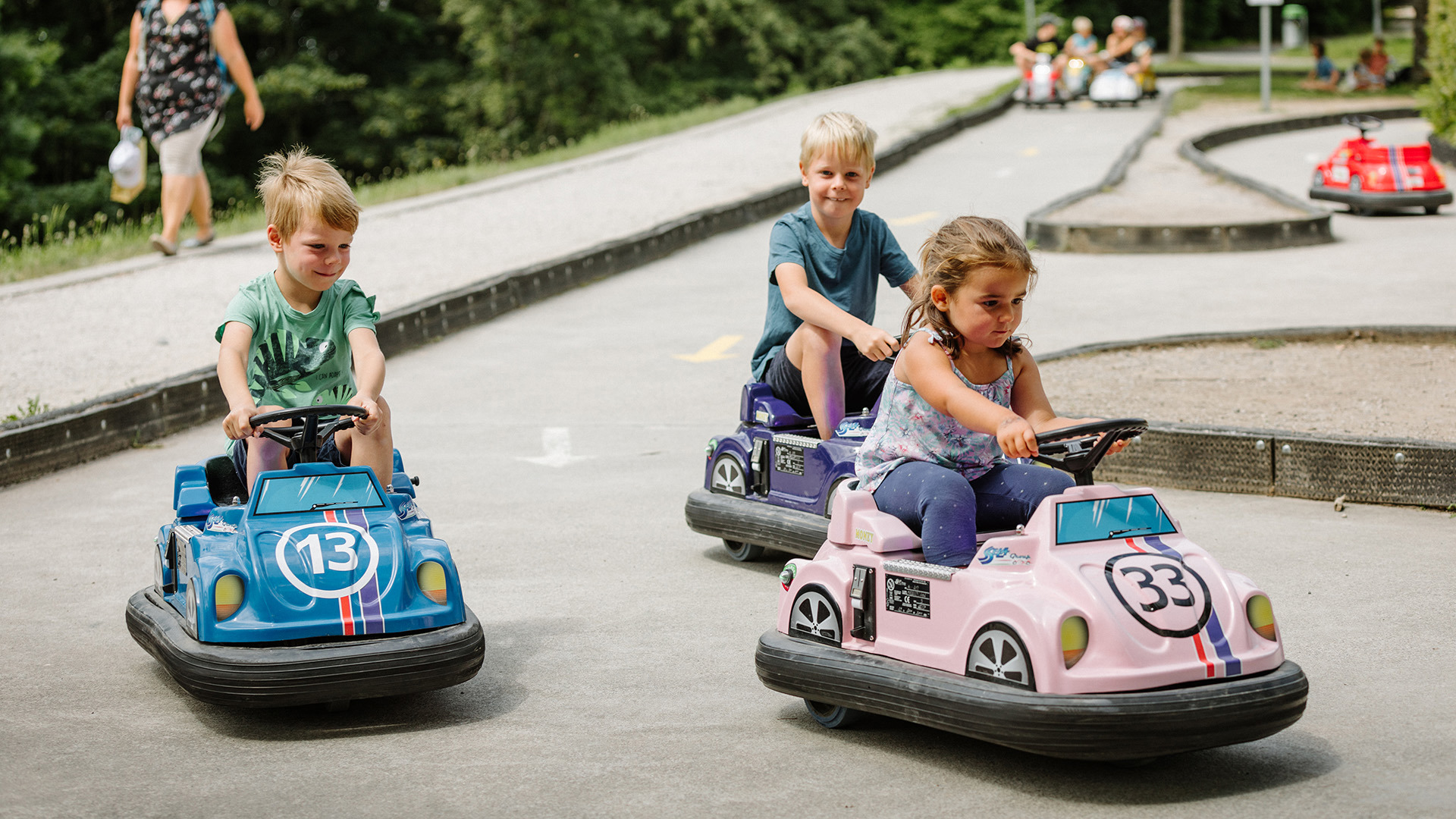 Three children are all driving in the same direction on Kids Car