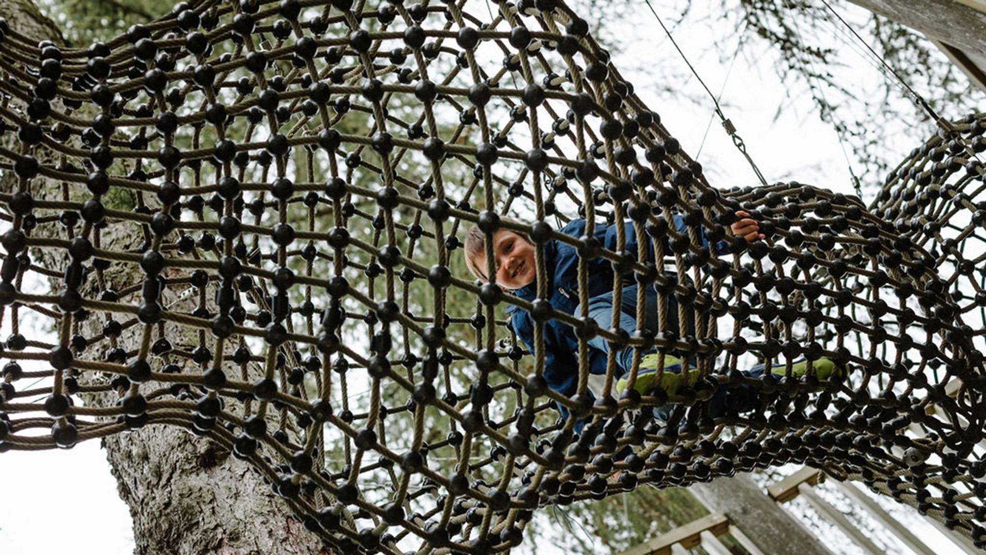 Child climbing on rope climbing frame