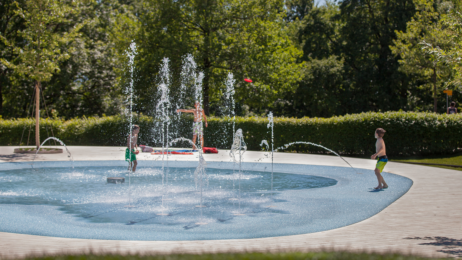 Two children playing in the water at Gurtenseeli